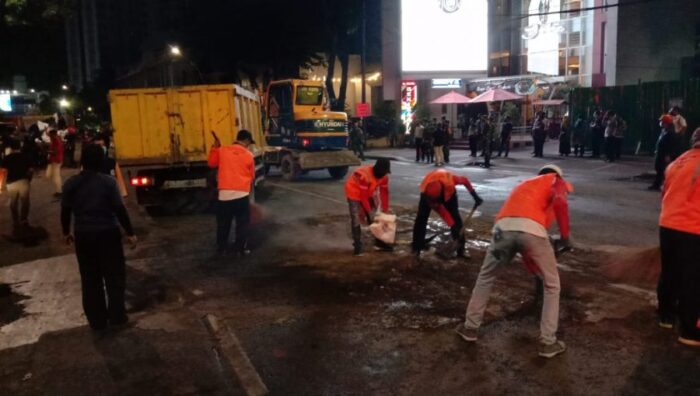 Petugas dari jajaran Pemkot Surabaya membersihkan puing-puing bekas aksi demo | Ist
