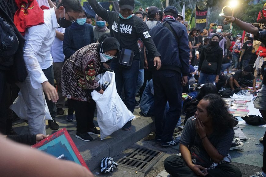 Sembari membawa karung, Wali Kota Surabaya Tri Rismaharini tampak memunguti sampah yang ada di antara pendemo /Ist