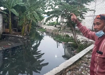 Ketua RW IV, Tambak Lumpang Kelurahan Sukomanunggal Surabaya saat menunjukkan kondisi sungai di sekitarnya /dok. Bicara Surabaya