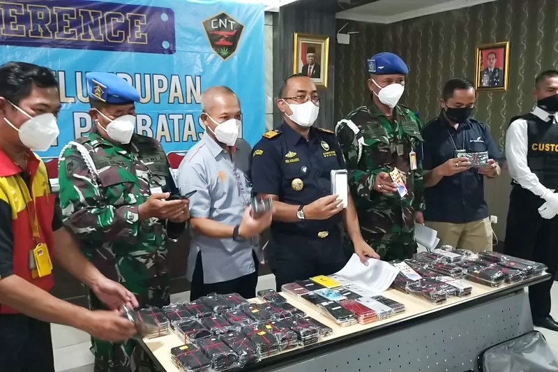Petugas menunjukan barang bukti telepon /foto: antara