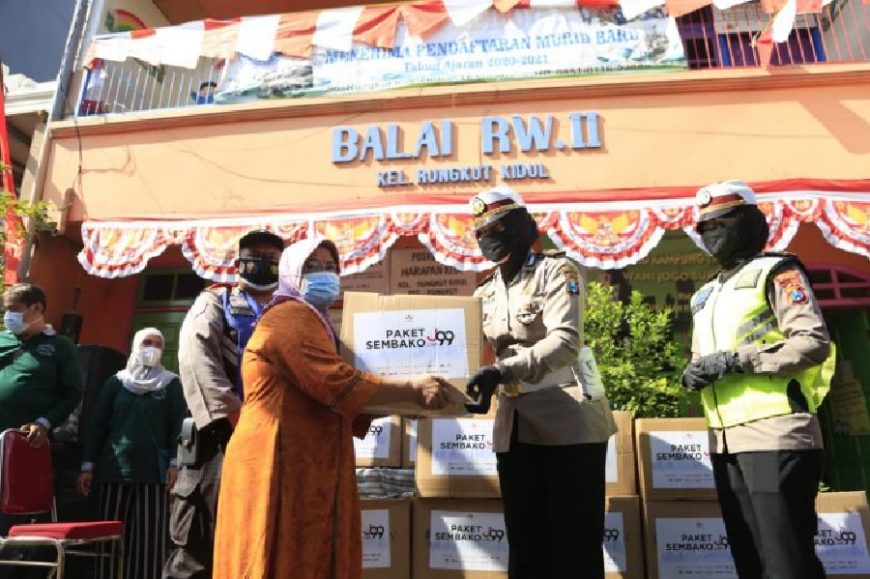 Polwan dari Polrestabes Surabaya menyerahkan bantuan paket sembako kepada warga di Balai RW II, Kelurahan Rungkut Kidul, Surabaya /Ist