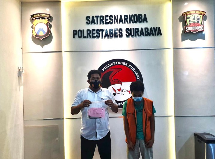 Tersangka HF (kanan) bersama barang bukti narkoba yang diamankan /Ist