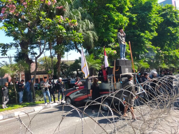Massa aksi saat memposisikan mobil komando mereka menutup Jalan Jaksa Agung Suprapto Surabaya, Senin (31/7/2023) /Foto: Bicara Surabaya