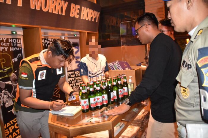 Petugas dari Satpol PP saat mengamankan botol minuman beralkohol di salah satu tempat Rekreasi Hiburan Umum (RHU) di Kota Surabaya /Istimewa 
