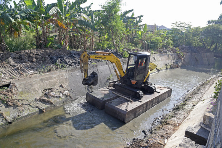 Alat berat dikerahkan untuk mengangkat sendimen lumpur di saluran utama. (Foto: Humas-Ist/BS)