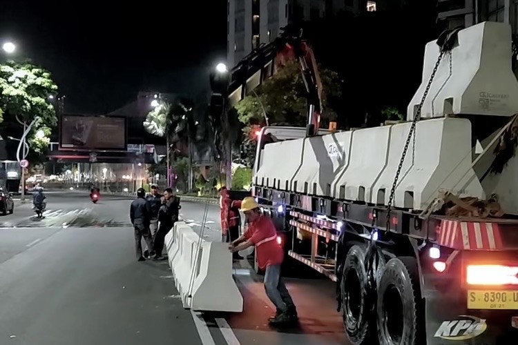 Petugas menurunkan barrier beton. (Foto: Humas Pemkot-Ist/BS)