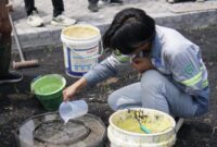Salah satu mahasiswa ITS saat melakukan pengujian infiltrasi pada inovasi paving porous dari fly ash di Desa Sumberejo, Probolinggo. (Foto: Humas ITS/BS)
