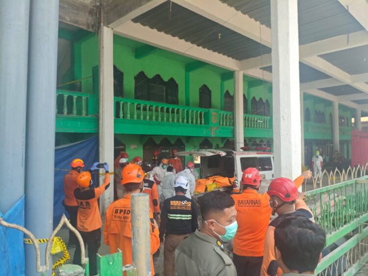 Petugas memasukkan kantung jenazah kedalam ambulan yang disiagakan untuk membawa ke RS Bhayangkara Polda Jatim. (Foto: BPBD Surabaya/BS)