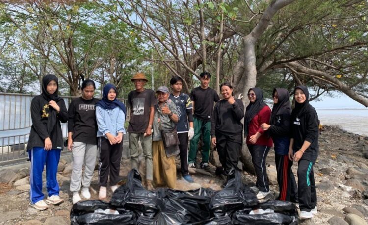 Para mahasiswa berfoto bersama warga dan penjaga pantai saat mengumpulkan sampah di pantai kenjeran Surabaya/dok.istimewa