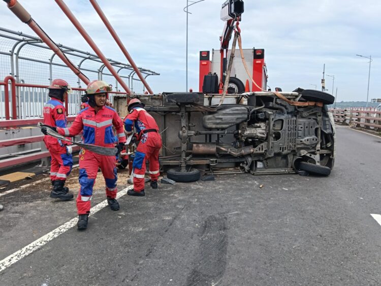 Petugas Rescue DPKP Surabaya mengevekuasi kendaraan yang terbalik. (Foto: CC112-Ist/BS)