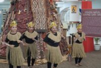 Empat mahasiswi PCU yang berasal dari Papua asyik menarikan tarian dari Papua di depan Pohon Natal “Terang dari Timur”. (Foto: Humas Kampus Petra/bs)