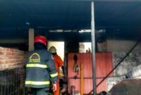 Petugas DPKP Surabaya melakukan pemadaman api di rumah di Jalan Jangkungan yang dilalap si jago merah. (Foto: CC 112-Ist/BS)