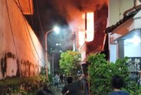 Warga berusaha menyelamatkan diri saat api melalap bangunan lantai 2 rumah yang terbakar. (Foto: Command Center 112)