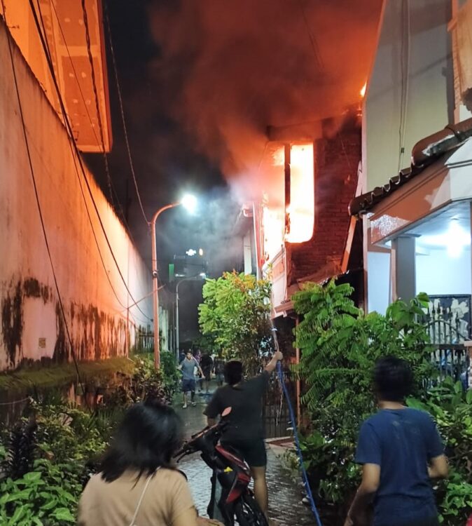 Warga berusaha menyelamatkan diri saat api melalap bangunan lantai 2 rumah yang terbakar. (Foto: Command Center 112)