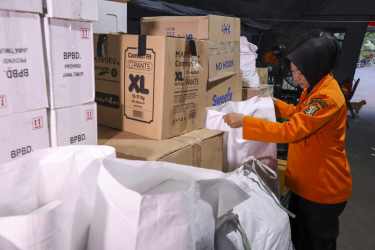 Petugas BPBS Surabaya merapikan bantuan yang akan dikirim ke Sumatera. (Foto: Dok humas Pemkot-Ist/bs)