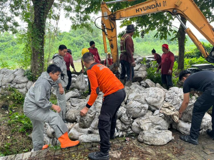 Petugas gabungan melakukan penanganan darurat terhadap tanggul jebol Sungai Jagir sisi Wonorejo. (Foto: Dok BPBD Surabaya)
