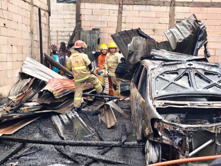Petugas melakukan pembasahan dilokasi kebakaran yang menghanguskan dua rumah di Asemrowo. (Foto: dok Command Center 112)