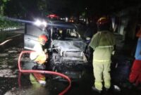 Petugas melakukan pembasahan usai memadamkan api yang membakar mobil yang ditumpangi satu keluarga. (Foto: dok Command Center 112)