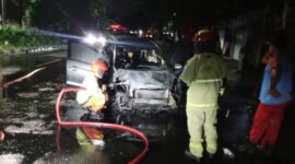 Petugas melakukan pembasahan usai memadamkan api yang membakar mobil yang ditumpangi satu keluarga. (Foto: dok Command Center 112)