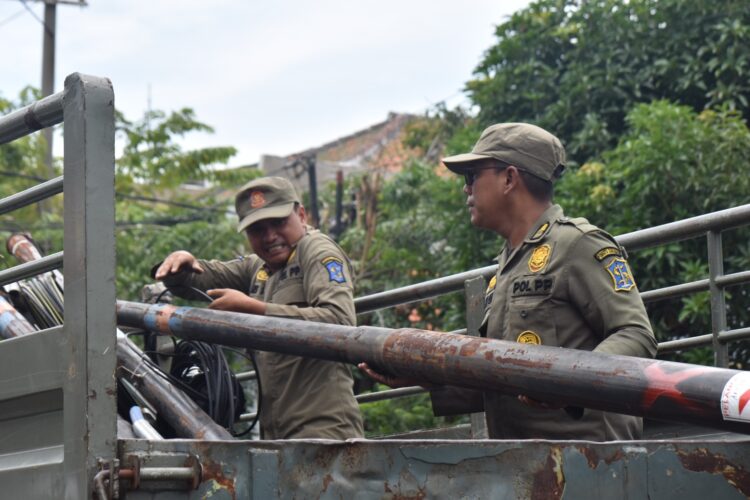 Petugas gabungan juga memotong tiang kabel fiber optik yang tidak berizin. (Foto: dok Satpol PP Surabaya)