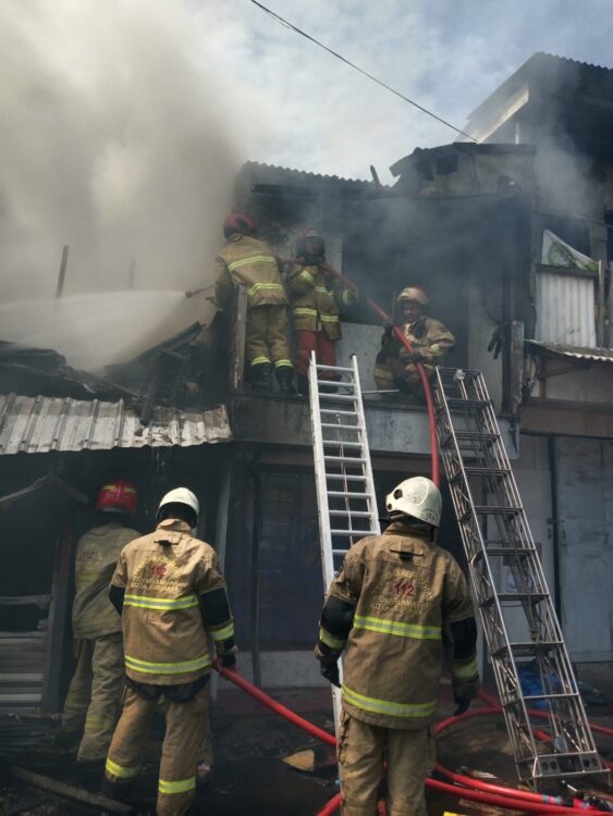 Petugaa damkar berusaha memadamkan api yang melalap sebuha rumah di kawasan Dupak, Kamis (5/3). Foto: dok Command Center 112