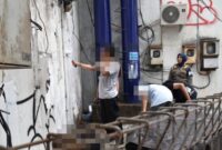 Pelaku vandalisme diberi sanksi sosial membersihkan tembok (dok. Satpol PP Surabaya)
