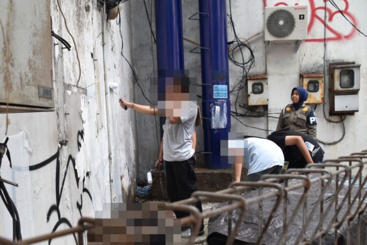 Pelaku vandalisme diberi sanksi sosial membersihkan tembok (dok. Satpol PP Surabaya)