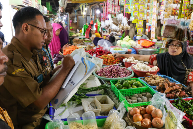 Petugas melakukan pengecekan harga bahan pokok di salah satu Pasar tradisional di Kota Surabaya (Foto: Pemkot Surabaya)