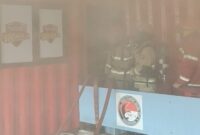 Petugas Damkar berusaha memadamkan api di ruang arsip lantai 3 Polres Tanjung Perak agar tidak merembet ke lantai di bawahnya dan ruangan lain. (Foto: dok Command Center 112)