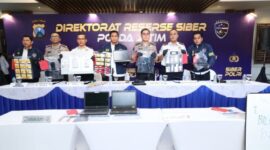 Petugas menunjukkan barang bukti kasus Love Scamming yang melibatkan WNA yang dibongkar oleh Polda Jatim. (Foto: Humas Polda Jatim)
