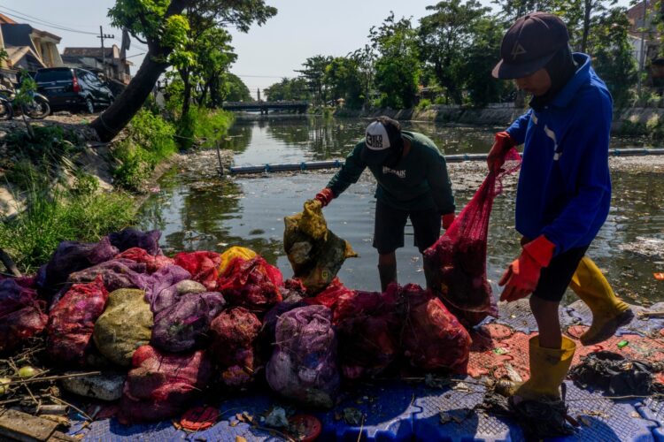 Petugas kebersihan membersihkan sampah di sungai/dok.Diskominfo Surabaya
