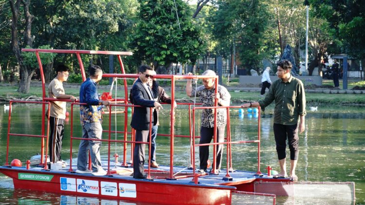 Rektor ITS Prof Dr (HC) Ir Bambang Pramujati ST MScEng PhD (berjas) bersama tim peneliti Kapal Pembersih Sampah Tanpa Awak melakukan uji coba kapal di danau Infinits ITS. (Foto: dok Humas ITS)