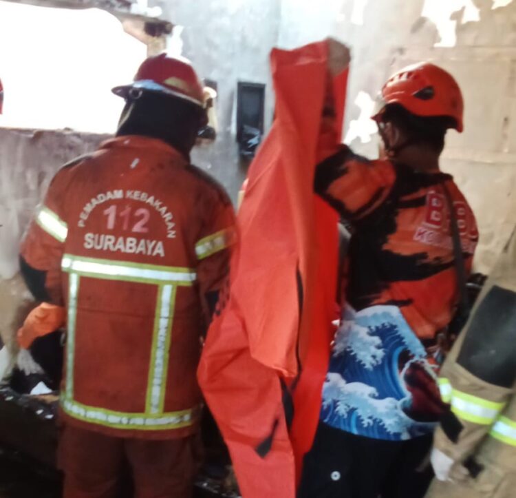 Petugas mengevakuasi jenazah balita yang terbakar dirumahnya di lantai 2. (Foto: Command Center 112)