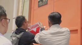 Petugas gabungan menempelkan stiker pelanggaran pada rumah kos yang tidak berizin. (Foto: dok Satpol PP Surabaya)